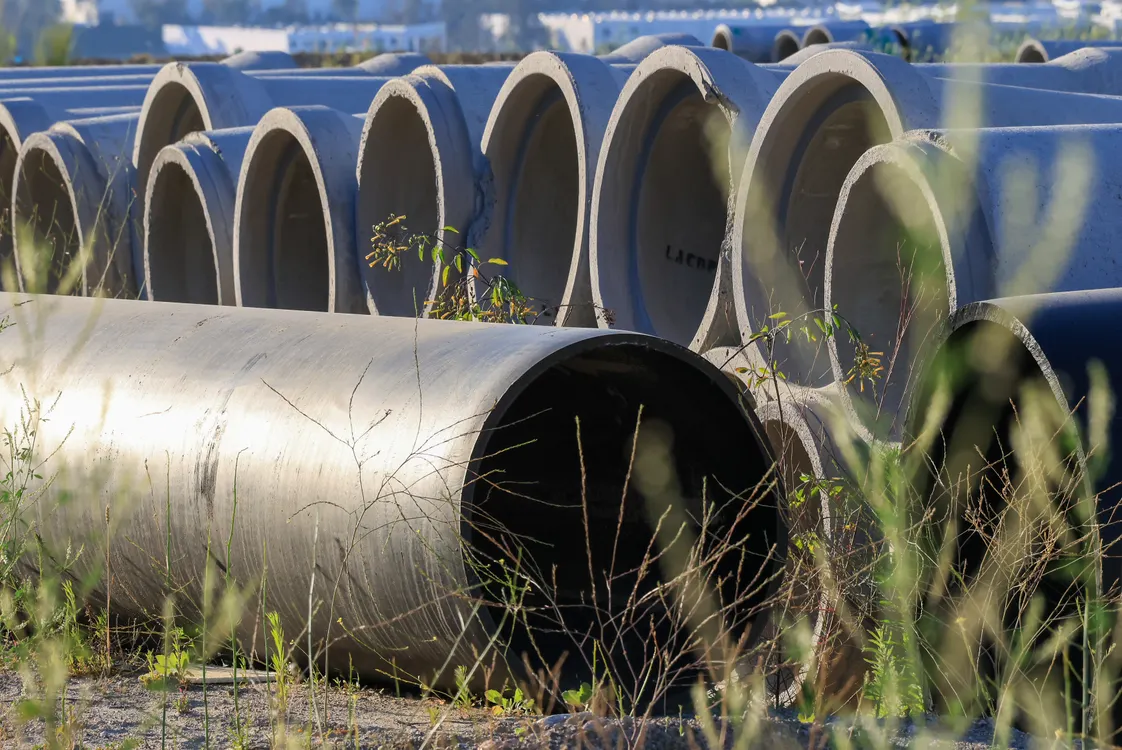 Trenchless sewer line repair Pittsburgh PA — stacked concrete sewer pipes in an outdoor storage area
